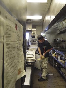 Carmody 61 head night cook Brian Godding preps burger plates. | KELSEY ROSETH