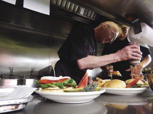 Chef Dan Morsette and cook Zach Morsette add the final touches to an order of burgers. | KELSEY ROSETH