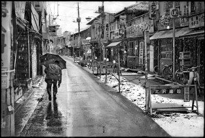 Inspired by the 1950's street photography, Ken Bloom traveled to Japan in 1976 to find his "decisive moment." His photograph, "Man with Umbrella" was taken a year later. | KEN BLOOM