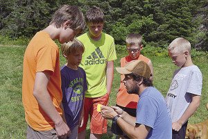 Service Team member and student leader Michael Lane teaches a group of boys how to read a map and compass. | LINDEN FIGGIE