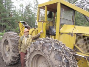 Duane Johnson of Hovland stands beside the skidder he purchased new in 1973. In an era where logging has been transformed with high-tech mechanization, he has continued to do things the old way. | SHAWN PERICH