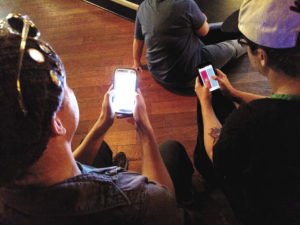 Audience members use their cell phones to play the interactive trivia game. | SUBMITTED