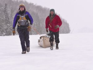 Amy and Dave Freeman haul their canoe down Newfound Lake at the end of Dec. as they prepare to swap their canoe for sled dogs and toboggans.