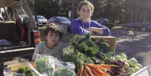 Eli and Mary June Wharton man the vegetable stand at a local farmer’s market. | SUBMITTED