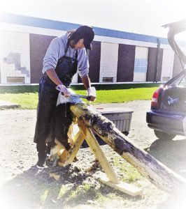 Garrick Waswa, age 16, scraping a deer hide. | MELISSA ROBERTS