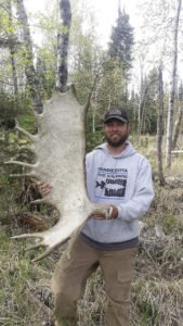 Joe Shead holding up a large moose antler he found in the spring of 2018.